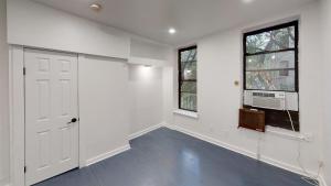 een lege kamer met een deur en een raam bij Apartment 1407: East Village in New York