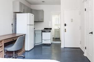 cocina con nevera, escritorio y silla en Apartment 1407: East Village en Nueva York