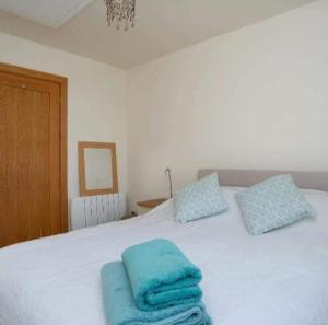 ein Schlafzimmer mit einem Bett mit blauen Handtüchern darauf in der Unterkunft Picton Lodge in Holywell