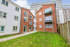an apartment complex with a grassy yard in front of buildings at Luxe & Stylish Central Luton 2Bed Apt - Fast Wi-Fi & Private Patio in Luton