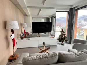 a living room with a television and a christmas tree at Kryształ Górski apartament z sauną in Szczyrk