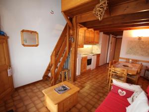 a living room with a staircase and a table and a kitchen at Appartement Villard-sur-Doron, 3 pièces, 6 personnes - FR-1-293-328 in Villard-sur-Doron
