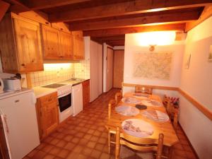 a kitchen with a wooden table and a table and chairs at Appartement Villard-sur-Doron, 3 pièces, 6 personnes - FR-1-293-328 in Villard-sur-Doron