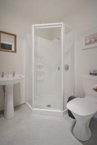 a bathroom with a shower and a toilet and a sink at Punakaiki Rocks Hotel & Garden Bar in Punakaiki