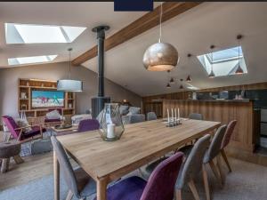 une salle à manger avec une table en bois et des chaises violettes dans l'établissement Maison Courchevel, 5 pièces, 8 personnes - FR-1-772-4, à Courchevel