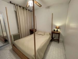 um quarto com uma cama de dossel num quarto em Appartement Port Camargue, 2 pièces, 6 personnes - FR-1-250-263 em Le Grau-du-Roi
