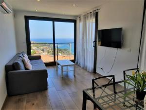 un soggiorno con divano e vista sull'oceano di Apartamento Llançà, 1 dormitorio, 4 personas - ES-170-74 a Llança