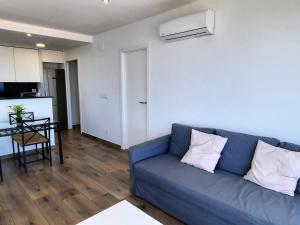 un soggiorno con divano blu e una cucina di Apartamento Llançà, 1 dormitorio, 4 personas - ES-170-74 a Llança