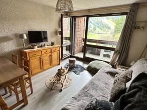 a living room with a bed and a television at Studio Corrençon-en-Vercors, 1 pièce, 5 personnes - FR-1-515-202 in Corrençon-en-Vercors