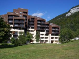 a large building with a grass field in front of it at Studio Corrençon-en-Vercors, 1 pièce, 5 personnes - FR-1-515-202 in Corrençon-en-Vercors