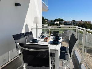 d'une table et de chaises blanches sur un balcon. dans l'établissement Appartement Vaux-sur-Mer, 4 pièces, 6 personnes - FR-1-539-57, à Vaux-sur-Mer