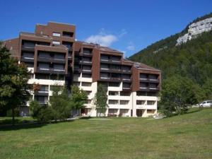 un gran edificio con un campo de césped delante de él en Studio Corrençon-en-Vercors, 1 pièce, 4 personnes - FR-1-515-204, en Corrençon-en-Vercors