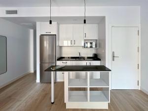 a kitchen with white cabinets and a stainless steel refrigerator at Picú Home - Nueva apertura in Málaga