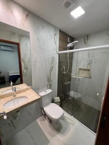 W łazience znajduje się toaleta, umywalka i prysznic. w obiekcie Pousada Amoré em Porto de Galinhas, PE w mieście Porto de Galinhas