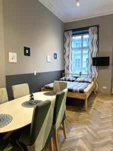 Cette chambre dispose de deux lits, de tables et d'une fenêtre. dans l'établissement Rabarbar, à Łódź