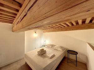 - une chambre avec un lit blanc et un plafond en bois dans l'établissement Cosy appt, Croix Rousse Duviard 1, à Lyon