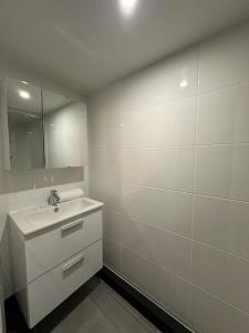 uma casa de banho branca com um lavatório e um espelho em Cosy appt, Croix Rousse Duviard 1 em Lyon
