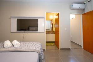 a bedroom with a bed with two towels on it at Botanical House, bairro Jardim Botânico 3 de Bsb in Brasilia