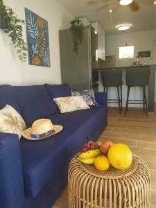 a blue couch with a bowl of fruit on a table at Casa MACON BLUE in Caleta De Fuste