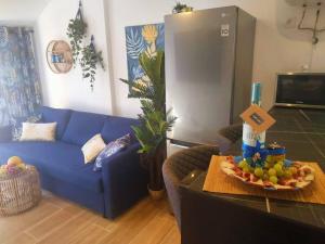 a living room with a blue couch and a bowl of fruit on a table at Casa MACON BLUE in Caleta De Fuste