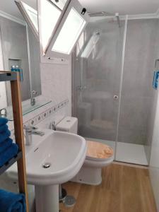 a bathroom with a sink and a shower and a toilet at Casa MACON BLUE in Caleta De Fuste