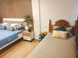 a bedroom with two beds and a table with a plant at Casa MACON BLUE in Caleta De Fuste