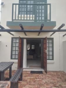 an open door of a house with a balcony at Modern two bedroom apartment. in Port Alfred