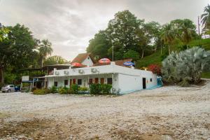 a house sitting on a gravel road with trees at Hotel Campestre El Refugio de Las Guacamayas in Puerto Triunfo