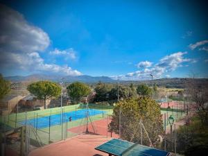 una piscina en un parque con pista de tenis en Casa Sierra norte de Madrid, en Navalquejigo