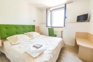 a bedroom with a large bed with a green headboard at A Sant'Anna in Albertacce