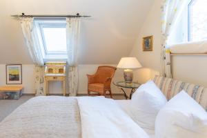 una camera da letto con un letto, un tavolo e una finestra di Westmarkenpalais a Sankt Peter-Ording