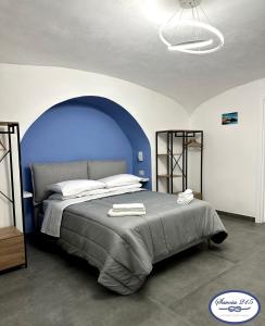 a bedroom with a large bed with a blue wall at Savoia 215 - Azzurra Guest House - Napoli in Naples