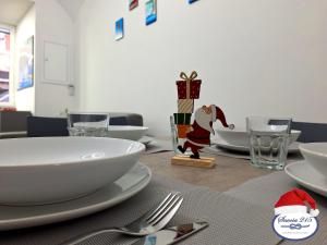 a table with white plates and a santa hat on it at Savoia 215 - Azzurra Guest House - Napoli in Naples