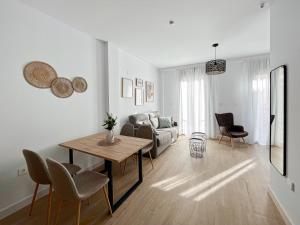 uma sala de estar com uma mesa e um sofá em Picú Home - Nueva apertura em Málaga