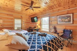 una camera da letto con un letto e un ventilatore a soffitto di Pet-Friendly Cabin with Hot Tub in Daniel Boone NF a Beattyville
