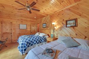 1 dormitorio con 2 camas en una cabaña de madera en Pet-Friendly Cabin with Hot Tub in Daniel Boone NF en Beattyville