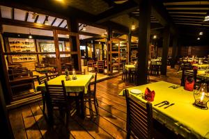 a restaurant with tables and chairs with yellow tablecloths at Melheim Resort and Spa in Haputale