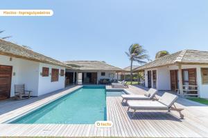 a villa with a swimming pool and a house at Vila Oásis no Pontal do Maceió Fortim Vista Mar in Fortim