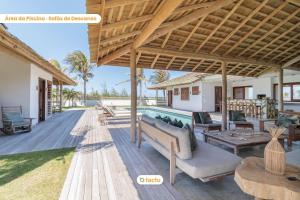 un patio al aire libre con piscina y un pabellón en Vila Oásis Luxo Vista Mar Pontal do Maceió Fortim en Fortim