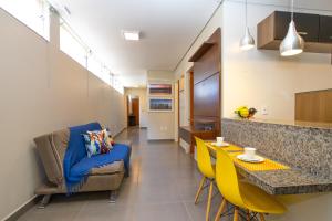 a living room with a blue couch and a table at Botanical House, bairro Jardim Botânico 3 de Bsb in Brasilia
