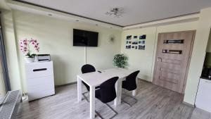 um escritório com uma mesa e cadeiras brancas e uma porta em Comfy Studio em Rzeszów