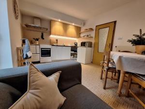 a living room with a couch and a kitchen at Villa Noce 1 - apartment with garden in Tesero