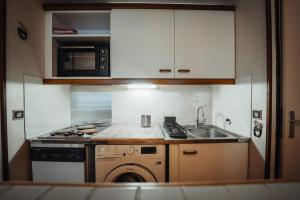 uma cozinha com um lavatório e um fogão forno superior em Apartment close to town center with mountain views em Saint-Gervais-les-Bains