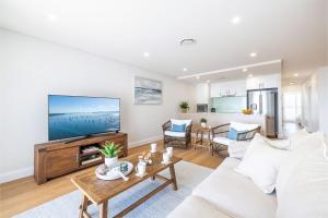a living room with a couch and a tv at The Shoal, 508, Bullecourt St - stunning views, air con, lift and Wi-Fi in Shoal Bay