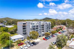 an apartment building in a parking lot with cars at The Shoal, 508, Bullecourt St - stunning views, air con, lift and Wi-Fi in Shoal Bay