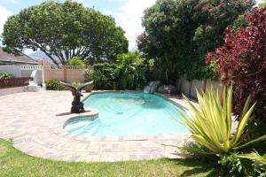 una piccola piscina con una statua in un cortile di The Dahlia a Città del Capo