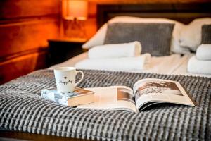 - un livre sur un lit avec une tasse et une tasse de café dans l'établissement Domki na Budzu, à Zakopane