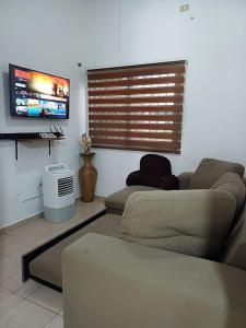 a living room with a couch and a flat screen tv at Descansa como en casa in San Miguel