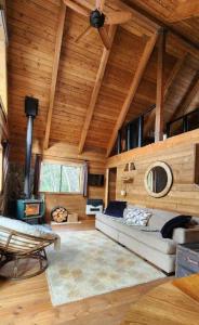 a living room with a couch and a wooden ceiling at Alpine Retreat: Off-Grid Cabin Winter Adventure in Pemberton