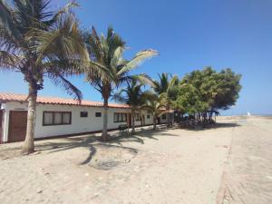 ein Gebäude mit Palmen davor in der Unterkunft Kite Hotel Máncora - Beach & Gym in Máncora